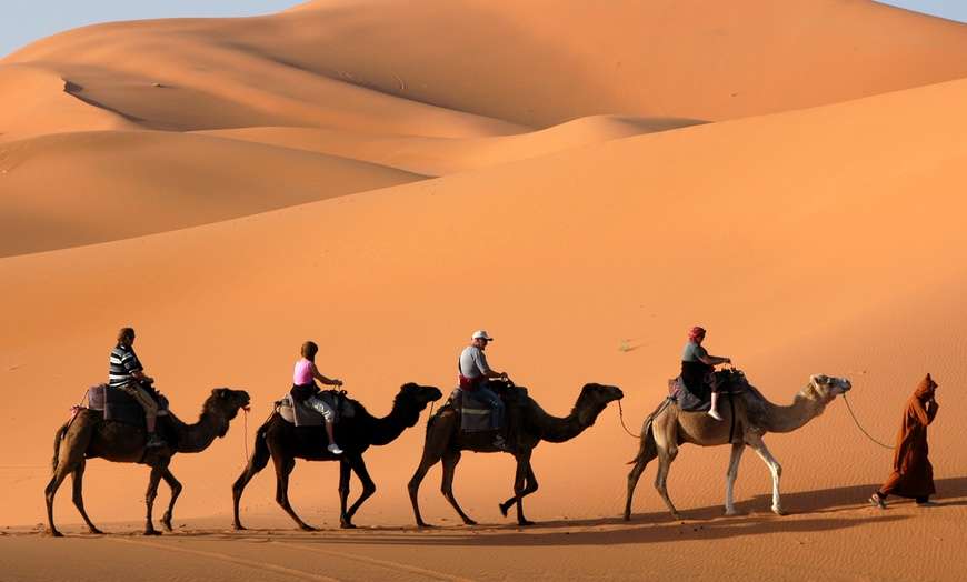 Image depicting a 4x4 vehicle traversing the mesmerizing red dunes of the Dubai desert during the Red Dune Bashing adventure with Dubai Dhow Cruises.